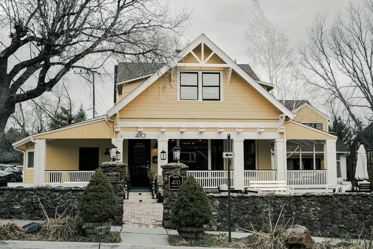 Freshly painted yellow craftsman home with crisp white trim and a covered front porch